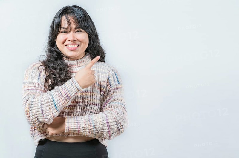 Beautiful asian woman pointing and presenting something, isolated. Cheerful asian girl pointing at a side isolated