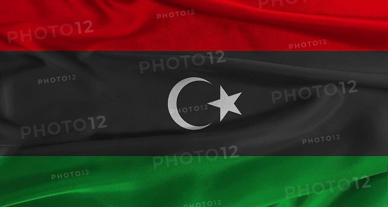 Flag of Libya with fabric textured background. Close up of National flag of Libya with realistic texture