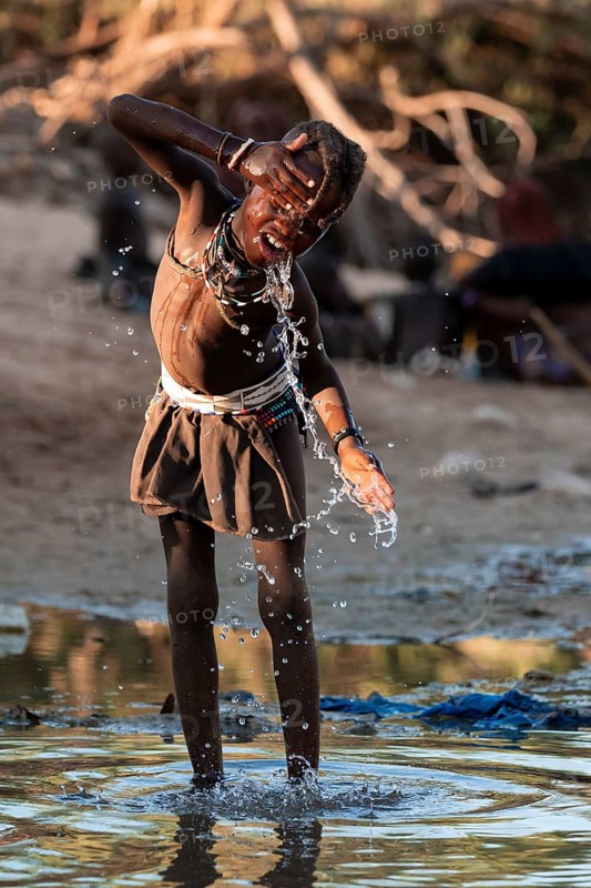 Himba child washing with water on a river, traditional Himba, Kaokoveld, Kunene, Namibia