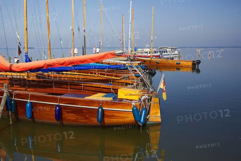 Several yachts are moored on the water in a quiet harbor, Steinhude Studer Meer