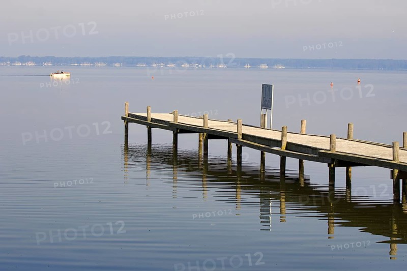 A lonely wooden walkway stretches into a quiet lake to the horizon, Steinhude, Steinhuder Meer