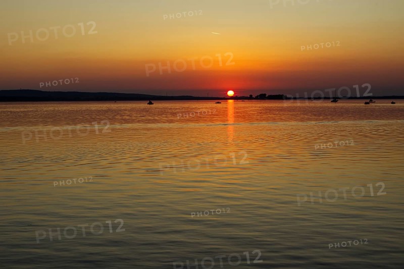 Sunset over a calm lake, orange sky, peaceful atmosphere, Steinhude Steinhuder Meer