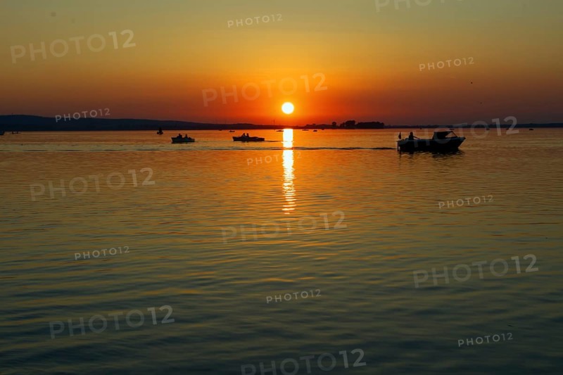 Sunset with several boats on Lake Steinhude, quiet evening mood, Steinhude