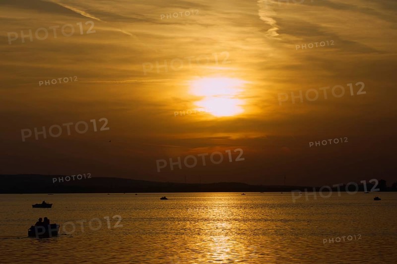 Several boats sail at atmospheric sunset on the lake, Steinhude, Steinhuder Meer