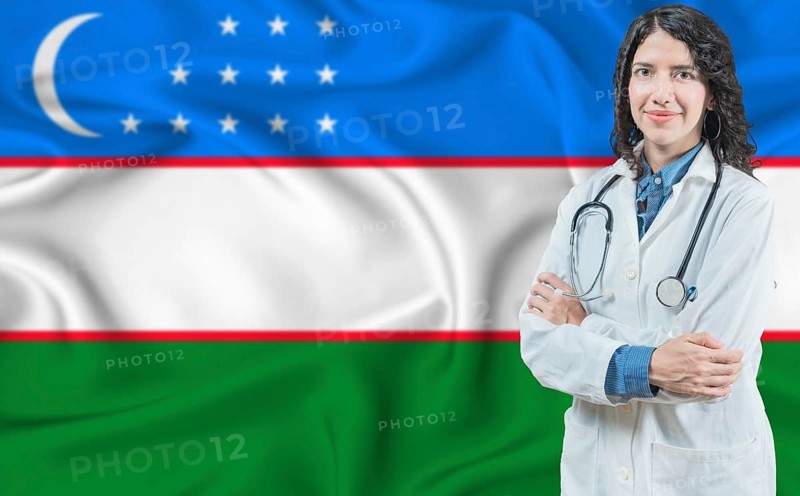 Uzbek medicine and healthcare concept. Doctor close up against Uzbekistan flag background