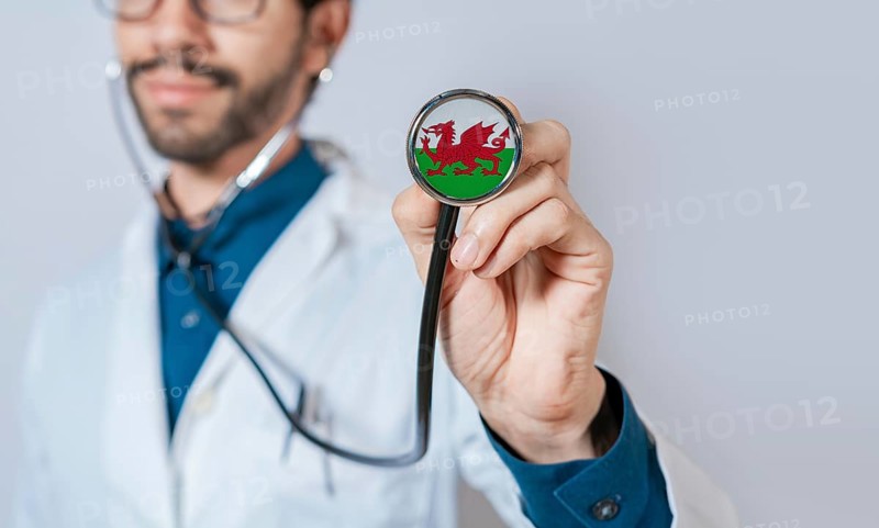 Doctor holding stethoscope with Wales flag. Wales health and care concept. Wales flag on stethoscope