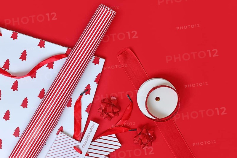 Top view of red and white Christmas wrapping material like bags, paper and ribbons