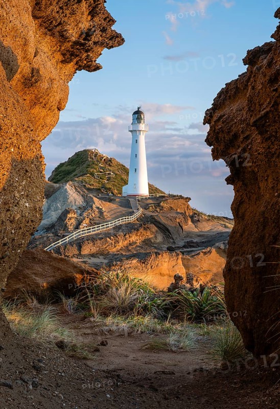 Castlepoint lighthouse on a rock, sea, sunrise. Castlepoint, Wairarapa Coast, Wellington Region, North Island, New Zealand