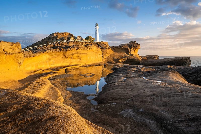 Castlepoint lighthouse on a rock, sea, sunrise. Castlepoint, Wairarapa Coast, Wellington Region, North Island, New Zealand