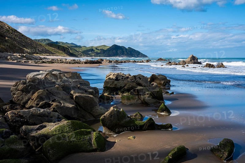 Castlepoint Beach, ocean, sandy beach, rocks, mountains. Castlepoint, Wairarapa Coast, Wellington Region, North Island, New Zealand