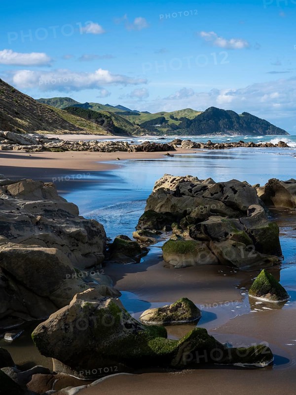 Castlepoint Beach, ocean, sandy beach, rocks, mountains. Castlepoint, Wairarapa Coast, Wellington Region, North Island, New Zealand