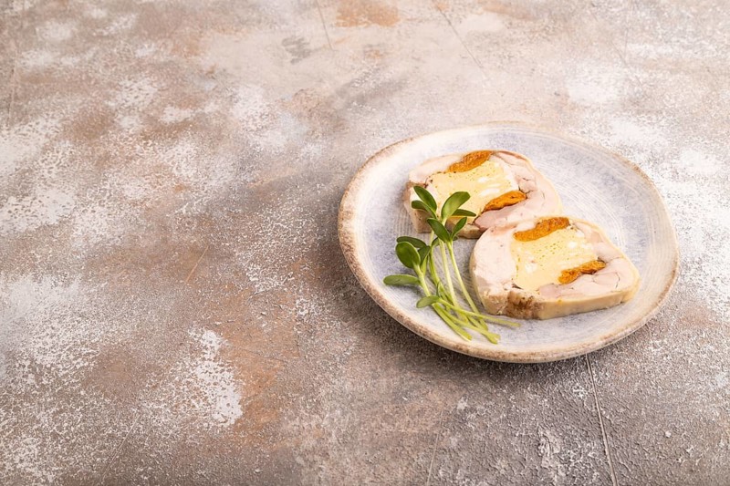 Chicken, egg and dried apricot meatloaf, microgreen on brown concrete background. side view, copy space
