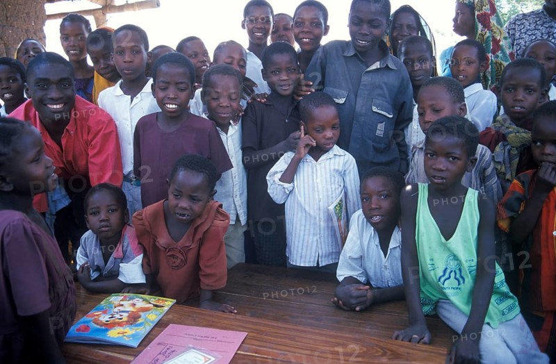 In a World Vision project, friends and neighbors have gathered on the occasion of a godfather's visit, Nyabubinza, Tanzania, Africa, June 2000, vintage, retro, old, historic