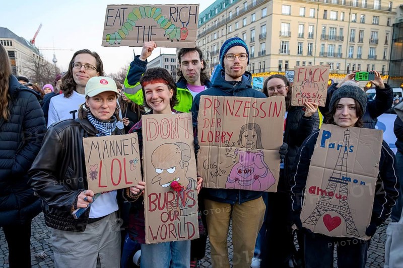 Activists from Fridays For Future holding cardboard signs at Fridays for Future rally on the tenth anniversary of the Paris Agreement at Pariser Platz, Berlin, 12.12.2025