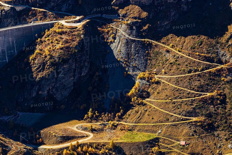 A hiking trail leads up to the dam of the Lac de Moiry reservoir, Val d'Anniviers, Valais Alps, Canton of Valais, Switzerland