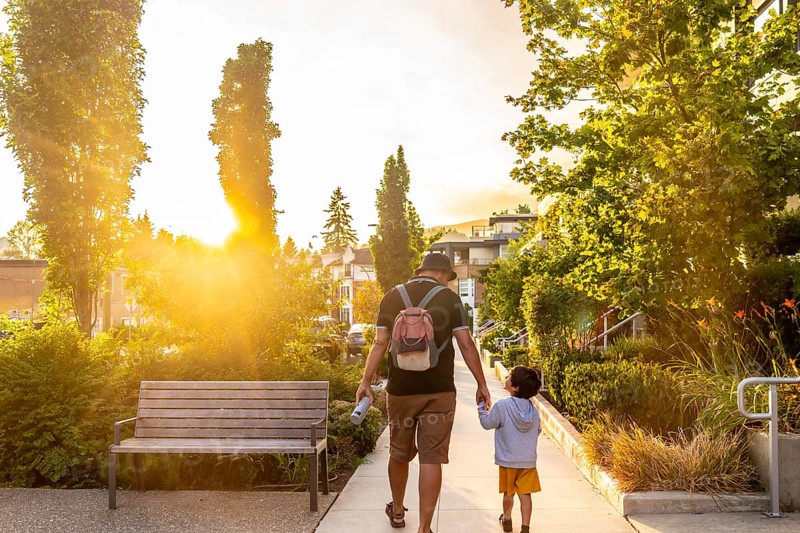 Father and son walking hand in hand at sunset in vancouver, cherishing quality moments together in a stunning urban landscape, surrounded by natures beauty and warm light