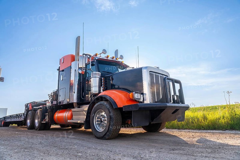 Powerful big rig semi truck with empty flatbed trailer parked on hemlock grove boardwalk in the canadian rockies, enjoying breathtaking sunset views