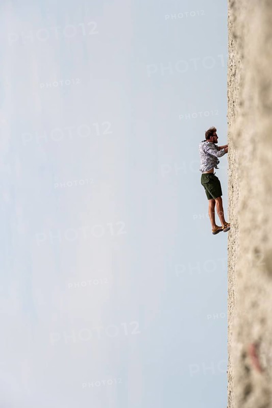 Symbolic picture, abstract, man climbing on wall, rotated image, on the Etosha pan, salt pan, Etosha National Park, Namibia