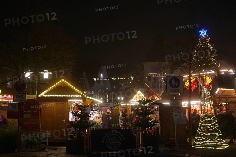 An atmospheric Christmas market in the dark with festively decorated huts and trees, Winterberg, North Rhine-Westphalia, Germany