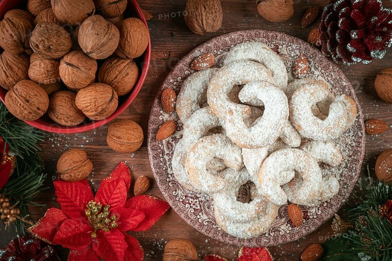 Vanilla croissants on a plate next to walnuts and Christmas decoration