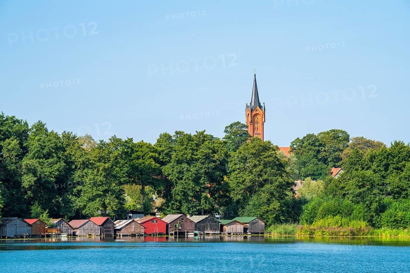 View across the Haussee to the town church and colorful boathouses on stilts, Feldberg, Feldberg Lake District, Mecklenburg-Western Pomerania, Germany