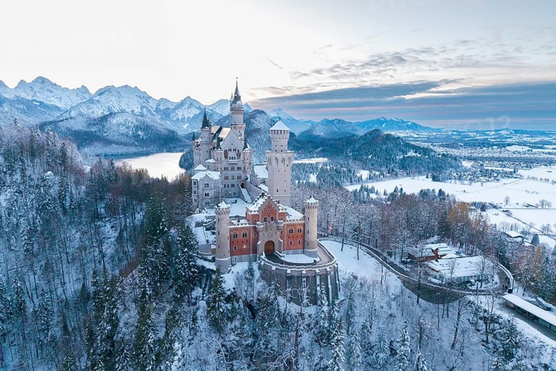 Snowy Neuschwanstein Castle at dusk, surrounded by mountains and soft winter light, Schwangau near Füssen, Ostallgäu, Allgäu, Bavaria, Germany