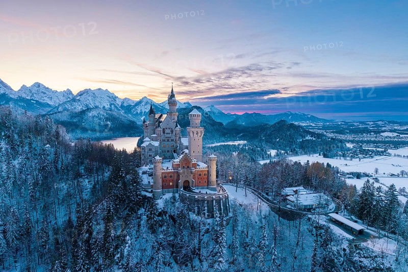Neuschwanstein Castle in winter at sunset with snow-covered mountains and peaceful atmosphere, Schwangau near Füssen, Ostallgäu, Allgäu, Bavaria, Germany