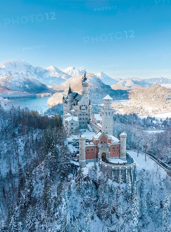 Neuschwanstein Castle in a wintry landscape with snow-covered mountains and blue sky, peaceful atmosphere, Schwangau near Füssen, Ostallgäu, Allgäu, Bavaria, Germany
