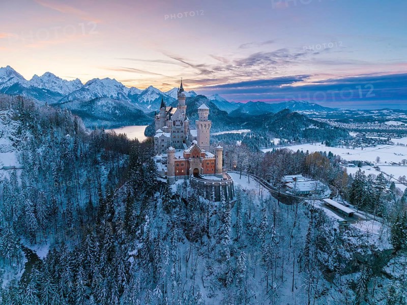 Fairytale castle Neuschwanstein in wintry evening, surrounded by snow-capped mountains, Schwangau near Füssen, Ostallgäu, Allgäu, Bavaria, Germany