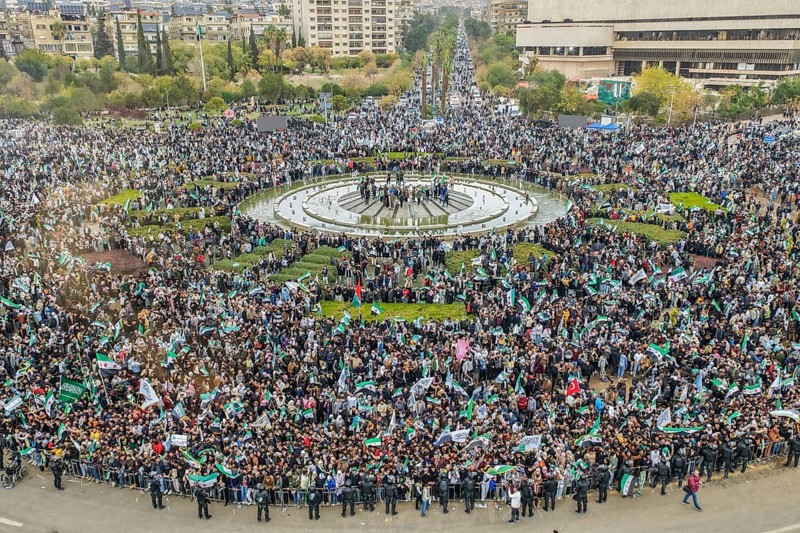 Damascus, Syria – December 08, 2025: A drone view shows thousands of people gathering in the iconic Umayyad Square in central Damascus, raising Syrian flags to celebrate the first anniversary of the fall of the Assad regime and the end of a devastating 14-year war that claimed hundreds of thousands of lives, Damascus, Damascus, Syria