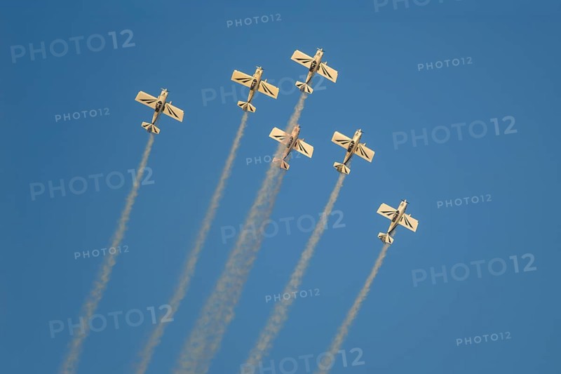Stunt aerobatic planes performing stunts in blue sky with smoke trail. Concept of teamwork, collaboration, coordination, trust, precision, difficulty, challenge, speed, synergy