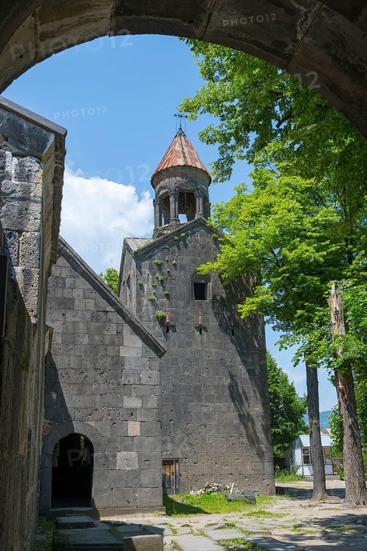 View through an arch of a church with bell tower, surrounded by trees, in shade, Sanahin monastery, Sanahin village, UNESCO World Heritage Site, Lorikeet province, Armenia