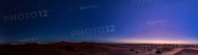 Starry sky over a desert-like landscape at dusk, Morocco, Sahara, in front of sunrise, panorama