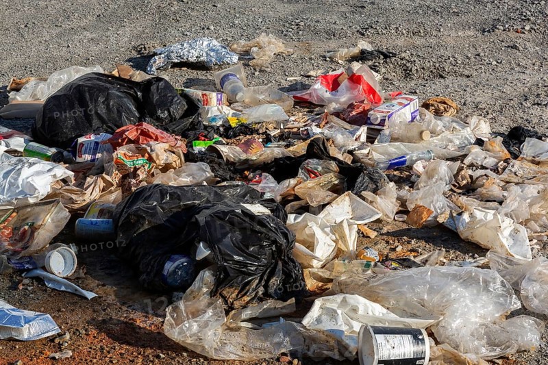 Recyclable plastic, paper and cardboard items discarded on the ground in public park, Quebec, Canada