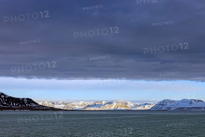 Snow covered mountains and glaciers debouching into Lilliehöökfjorden, fjord branch of Krossfjorden in Albert I Land, Spitsbergen / Svalbard, Norway