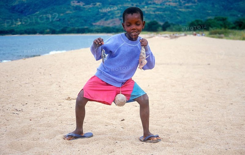 Little boy posing with caught fish for camera, Chitimba, Lake Malawi, Africa, July 2000, vintage, retro, old, historic