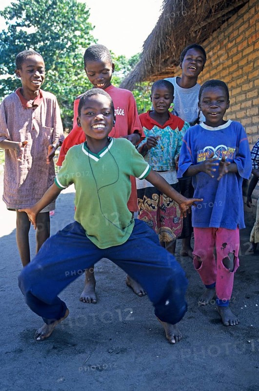 Local children dance happily to music in a village near Kande, Lake Malawi, Malawi, Africa, July 2000, vintage, retro, old, historic