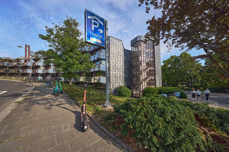 Theatre car park, modern architecture, sidewalk, e-scooter, traffic sign parking garage, trees, bushes, lawn, pedestrians as accessories, blue sky, cumulus clouds, evening light, Parkstraße and Paulinenstraße roads, Wiesbaden, state capital, district-free city, Hesse, Germany