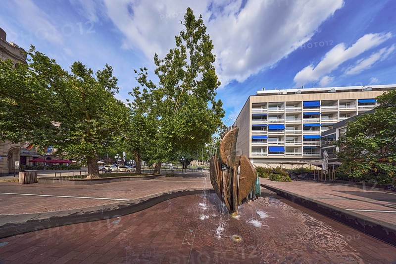 Fountain complex, bronze sculpture, sculptor Ernst Dostal, general architecture, residential and commercial buildings, trees, Kaiser-Friedrich-Platz, Wiesbaden, state capital, district-free city, Hesse, Germany