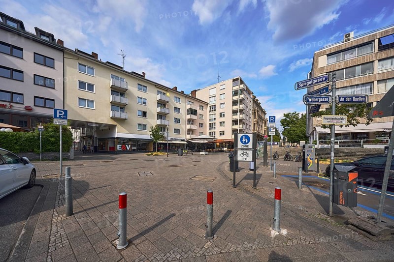 Pedestrian zone, traffic sign pedestrian zone, additional sign for cyclists free, traffic sign parking, road signs, barrier bollards, general architecture, houses, residential buildings and commercial buildings, balcony, window, road surface made of concrete paving stones, trees, blue sky, cumulus clouds, intersection Spiegelgasse with Webergasse and An den Quellen, Wiesbaden, state capital, district-free city, Hesse, Germany
