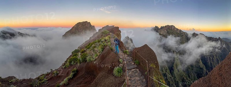 Photographer photographs sunrise at Pico do Arieiro, clouds of fog sweeping over mountain peaks, sea of fog, hiking trail PR1, Madeira, Portugal