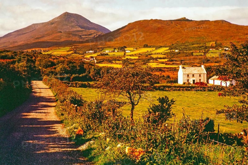 Farmland and rural landscape country road leading towards Derryveagh Mountains mountain range, County Donegal, Ireland 1960s