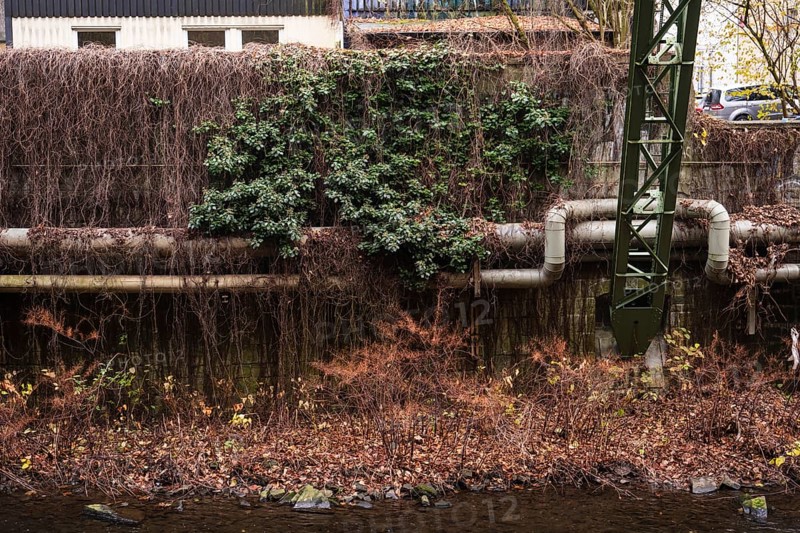 District heating pipeline in front of old industrial buildings on the banks of the Wupper, Wuppertal, Germany