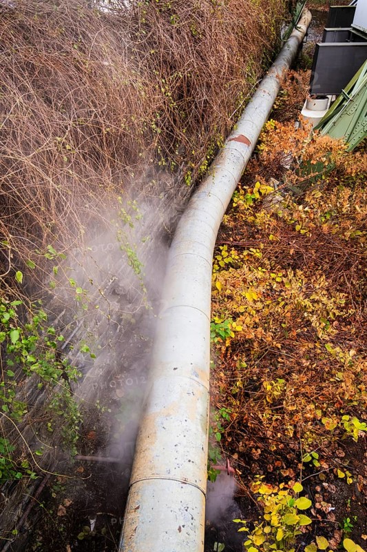 District heating pipeline in front of old industrial buildings on the banks of the Wupper, Wuppertal, Germany