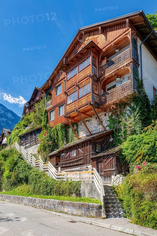A, Hallstatt, hdr, A traditional wooden house covered with ivy, along a staircase under a blue sky, Austria