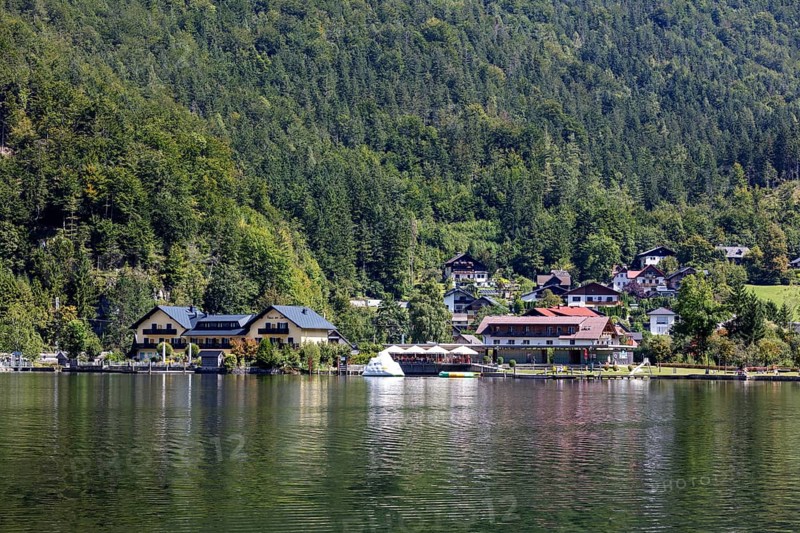A, Hallstatt, A small lakeside village with boats and green forests in the background, Austria