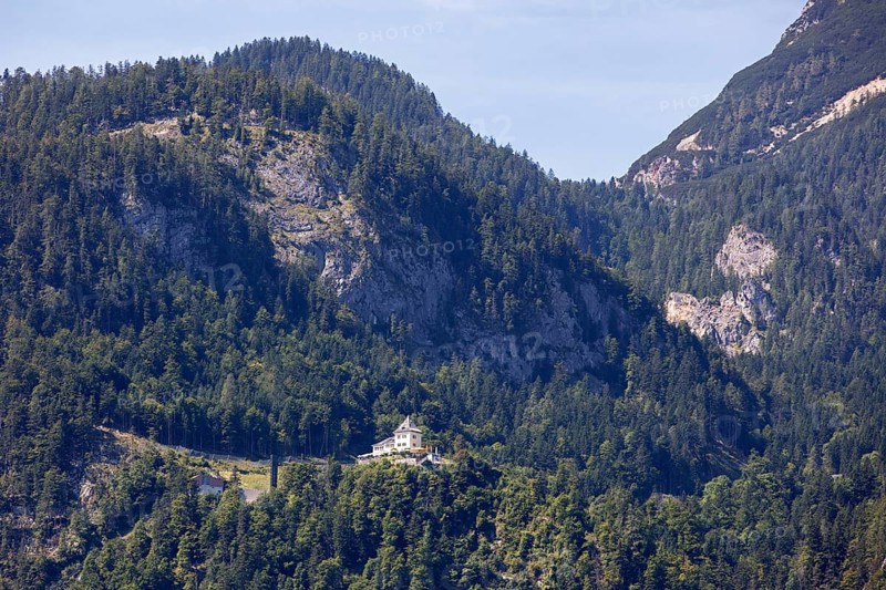 A, Hallstatt, A castle on a wooded mountainside surrounded by towering peaks, Austria
