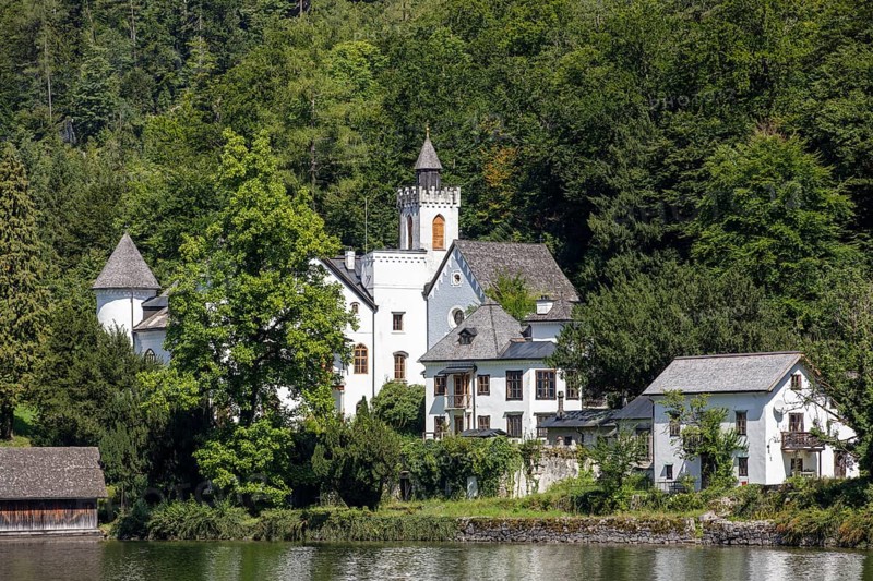 A, Hallstatt, A castle with towers and surrounding buildings on the lake, surrounded by forest, Austria