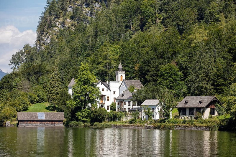 A, Hallstatt, An estate with several buildings on the shores of a lake, surrounded by trees, Austria