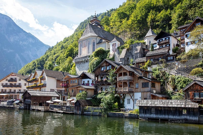 A, Hallstatt, houses on the water in front of green mountains, traditional architecture in picturesque surroundings, Austria